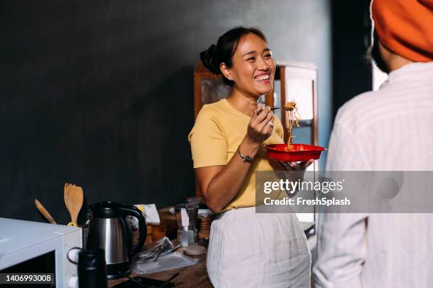 a beautiful smiling woman having lunch and enjoying talking to her unrecognizable boyfriend - woman junk food eating stock pictures, royalty-free photos & images