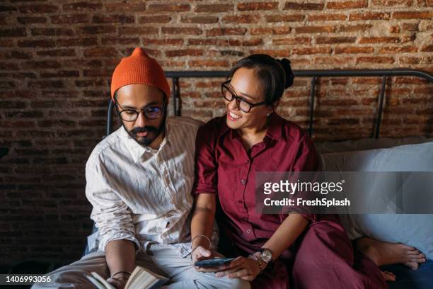 a happy mixed-race couple wearing glasses enjoying spending their leisure time together - man 30s stock pictures, royalty-free photos & images