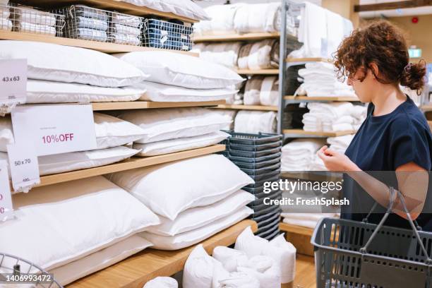 woman shopping for pillows - bedclothes stockfoto's en -beelden