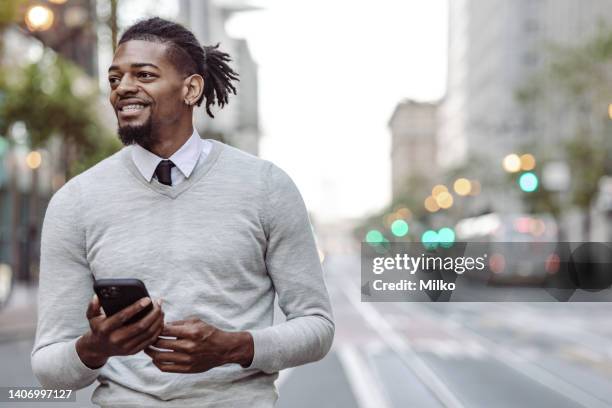 african-american man using smart phone and walking - preppy stock pictures, royalty-free photos & images