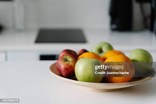 tray with apples and oranges on the kitchen counter - fruchtzucker stock-fotos und bilder