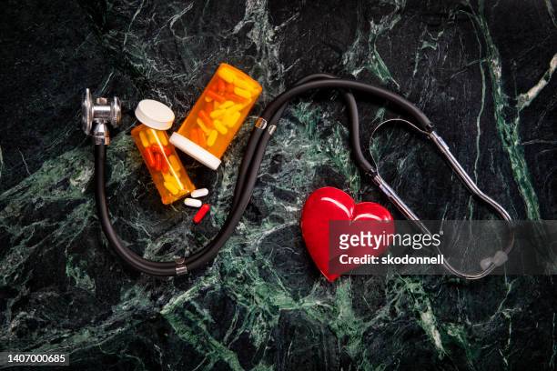 緑の大理石の背景に聴診器とヘルスケアの概念 - heart pill ストックフォトと画像