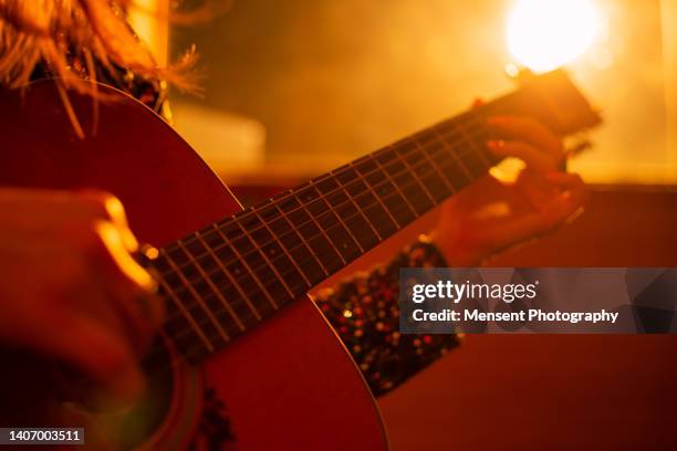 woman playing guitar at music studio - akustikgitarre stock-fotos und bilder