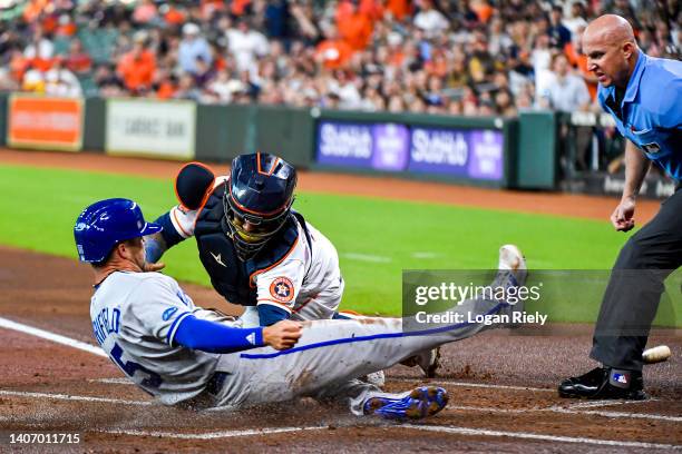 Whit Merrifield of the Kansas City Royals slides safely into home plate during their game against the Houston Astrosat Minute Maid Park on July 05,...