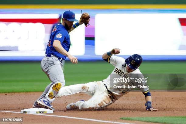 Christian Yelich of the Milwaukee Brewers slides safely into third base as Patrick Wisdom of the Chicago Cubs attempts the tag during the game at...