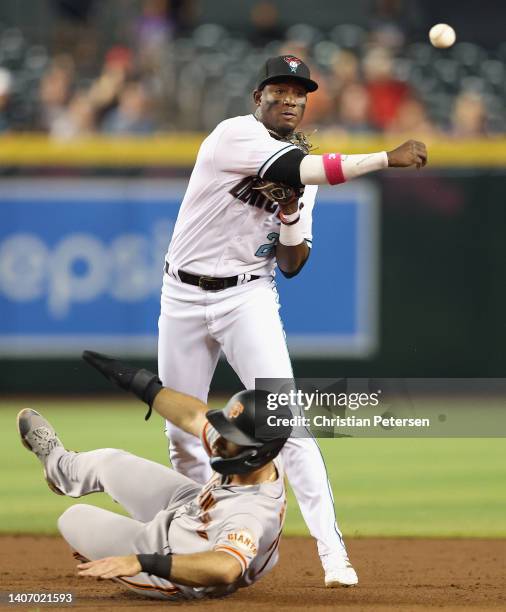 Infielder Geraldo Perdomo of the Arizona Diamondbacks throws over David Villar of the San Francisco Giants attempting a double play during the third...