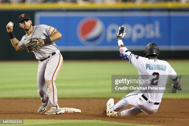 Infielder David Villar of the San Francisco Giants throws over Geraldo Perdomo of the Arizona Diamondbacks to complete a double play during the third...