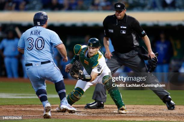 Alejandro Kirk of the Toronto Blue Jays is tagged out at home plate by catcher Sean Murphy of the Oakland Athletics in the top of the sixth inning at...