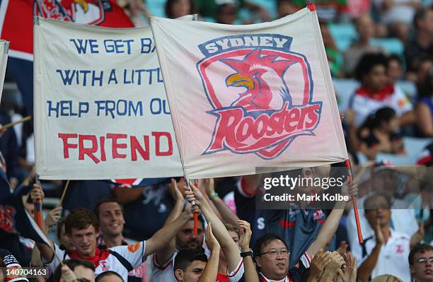 Roosters supporters in the crowd cheer during the round one NRL match between the South Sydney Rabbitohs and the Sydney Roosters at ANZ Stadium on...