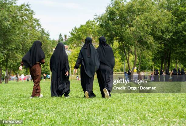 group of young muslim women wearing hijab walking on a park near beykoz, istanbul, turkiye - burka stock pictures, royalty-free photos & images
