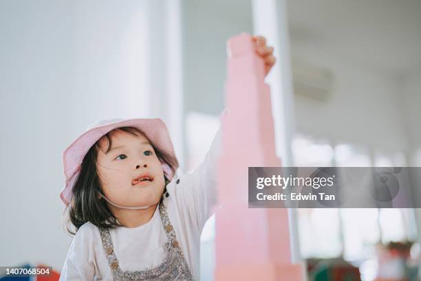 asian chinese prescool girl finishing final piece toy block building tower in montessori classroom - asian kid raising hand bildbanksfoton och bilder