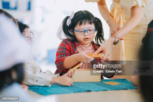 asian montessori preschool student playing wood toy block in classroom - preschool student 個照片及圖片檔