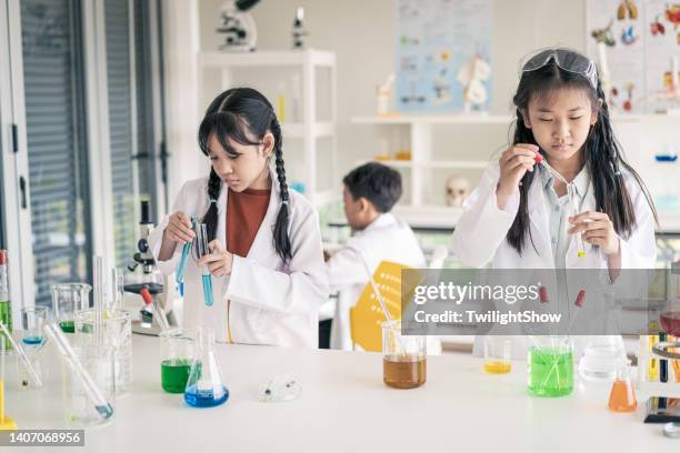 schüler und freunde aus kindertagen, die im klassenzimmer naturwissenschaften lernen - science lab school stock-fotos und bilder