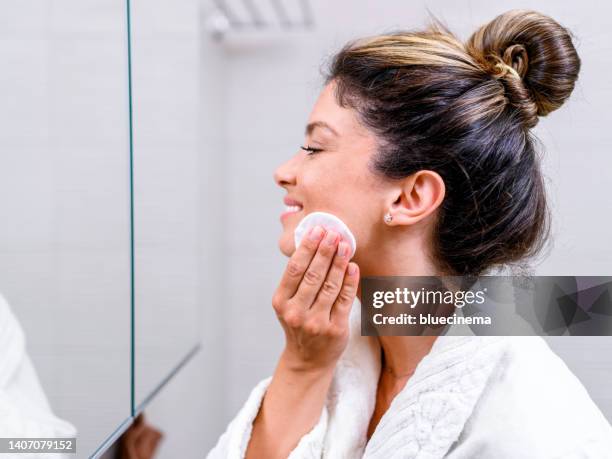 woman in bathrobe cleaning her face - make up verwijderen stockfoto's en -beelden