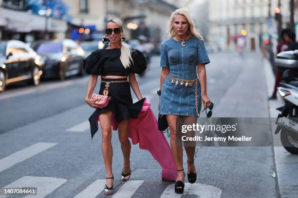 Denisa Palsha seen wearing black sunglasses, gold large earrings, a black oversized ruffled shoulder crop top, a black and pink wrap/oversized...