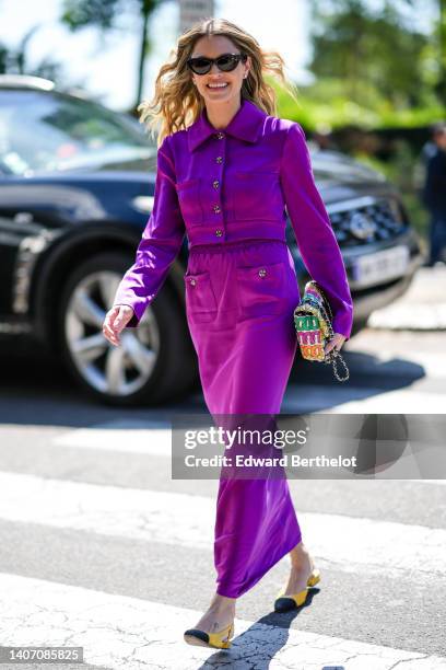 Helena Bordon wears black sunglasses, a neon purple jacket from Chanel, a matching neon purple long skirt from Chanel, diamond earring, a...