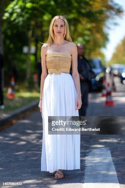 Lauren Santo Domingo wears a beige braided wicker shoulder-off / cropped top, a high waist white pleated long skirt, brown suede strappy sandals ,...