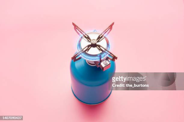 still life of a gas stove burner with burning gas on pink background - quemador fotografías e imágenes de stock
