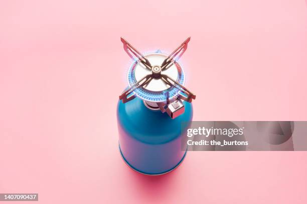 still life of a gas stove burner with burning gas on pink background - camping stove stockfoto's en -beelden