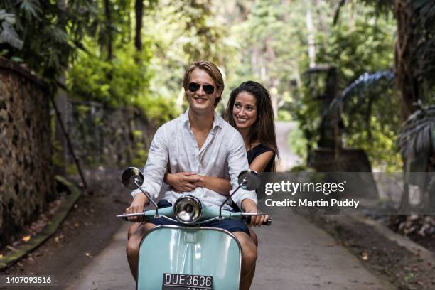 young couple riding classic scooter during vacation in bali - bali 個照片及圖片檔