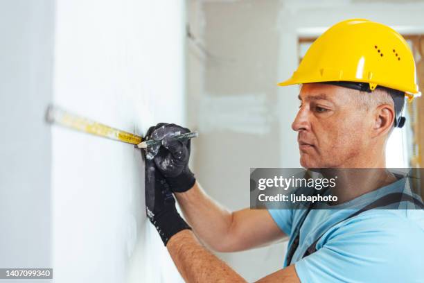 workman wearing hardhat working at construction site - 50 meter stock pictures, royalty-free photos & images