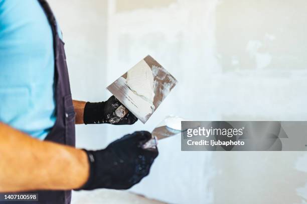 plastering un mur - plaquiste photos et images de collection