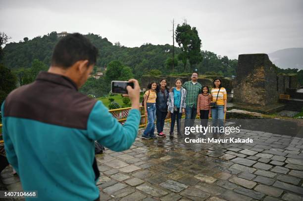 a tourist guide taking photographs of group of tourist families at old stone ruins - monsoon stock pictures, royalty-free photos & images