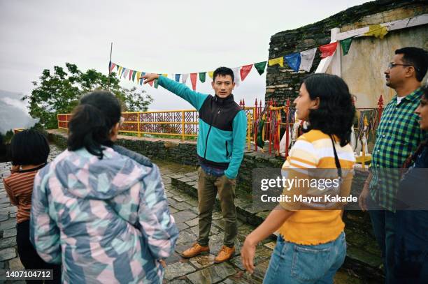 a tourist guide explaining to tourist families at old stone ruins - indian tour guide stock pictures, royalty-free photos & images