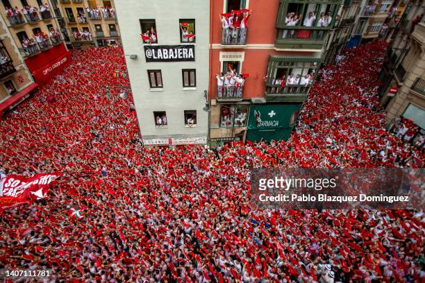 Revelers hold up their red handkerchiefs as they enjoy the atmosphere during the opening day or 'Chupinazo' of the San Fermin Running of the Bulls...