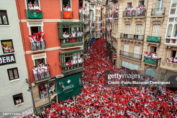 Revellers hold up their red handkerchiefs as they enjoy the atmosphere during the opening day or 'Chupinazo' of the San Fermin Running of the Bulls...