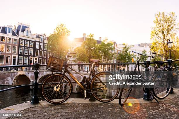 bicycle by the canal in amsterdam, netherlands - amsterdam bike stockfoto's en -beelden