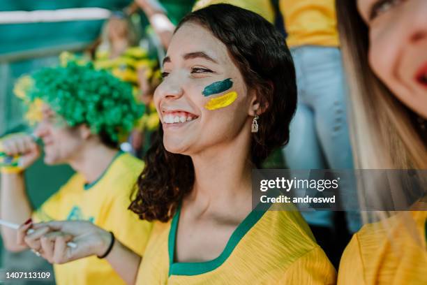 happy brazilian fans at the stadium - a brazil supporter stockfoto's en -beelden