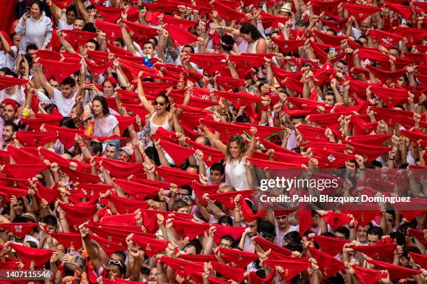 Revellers hold up their red handkerchiefs as they enjoy the atmosphere during the opening day or 'Chupinazo' of the San Fermin Running of the Bulls...