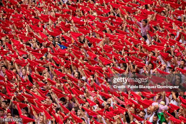 Revellers hold up their red handkerchiefs as they enjoy the atmosphere during the opening day or 'Chupinazo' of the San Fermin Running of the Bulls...