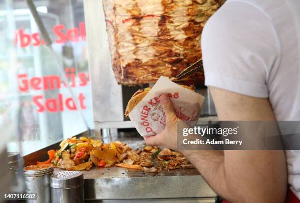 An employee prepares a customer's order at Mustafas Gemüse Kebap on July 06, 2022 in Berlin, Germany. The döner kebab, a fast food sandwich made of...