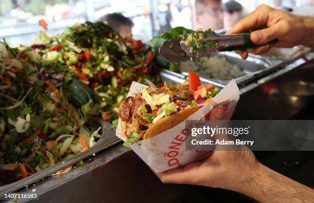 An employee prepares a customer's order at Mustafas Gemüse Kebap on July 06, 2022 in Berlin, Germany. The döner kebab, a fast food sandwich made of...