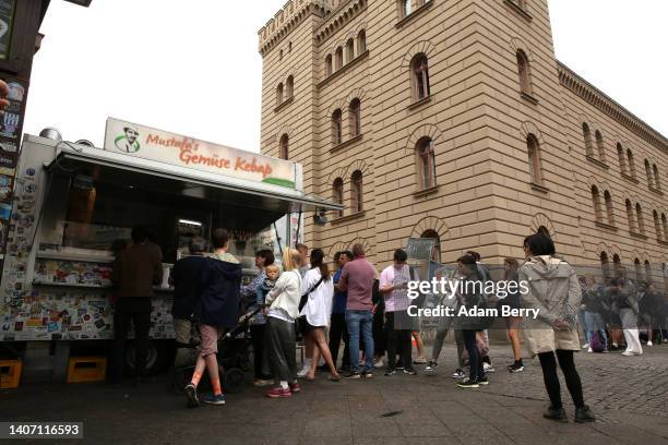 Visitors stand in line to order at Mustafas Gemüse Kebap on July 06, 2022 in Berlin, Germany. The döner kebab, a fast food sandwich made of stacked,...