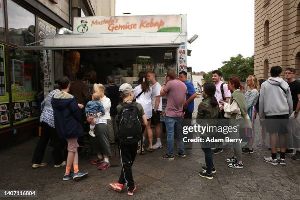 Visitors stand in line to order at Mustafas Gemüse Kebap on July 06, 2022 in Berlin, Germany. The döner kebab, a fast food sandwich made of stacked,...