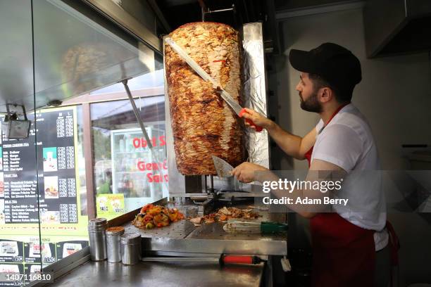 An employee prepares a customer's order at Mustafas Gemüse Kebap on July 06, 2022 in Berlin, Germany. The döner kebab, a fast food sandwich made of...