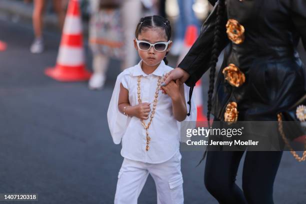Guest seen wearing an oversized leather jacket with golden rose buttons, a black leather bag with golden details and a black leggings; her child seen...