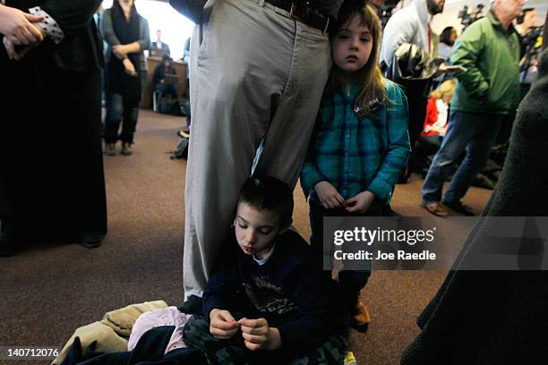 People listen as Republican presidential candidate, former U.S. Sen. Rick Santorum speaks during a campaign rally at the Dayton Christian School on...