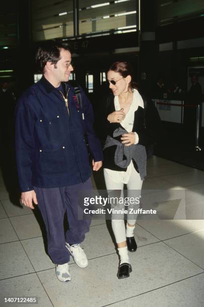American actor Matthew Broderick, wearing a blue jacket, and American actress Sarah Jessica Parker, wearing a white outfit with a black cardigan and...