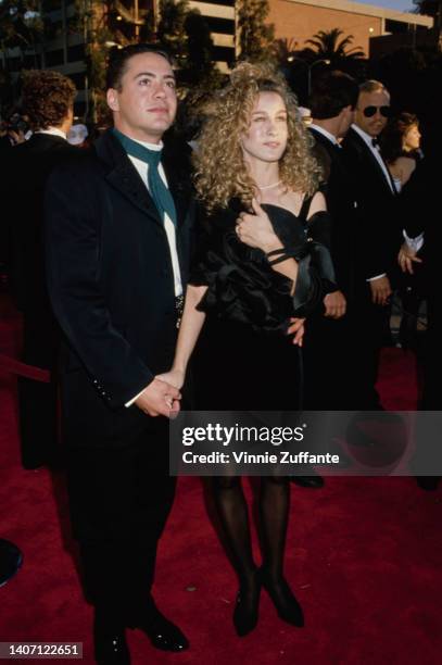 American actor Robert Downey Jr, wearing a black suit with a white shirt and teal tie, and his partner, American actress Sarah Jessica Parker,...