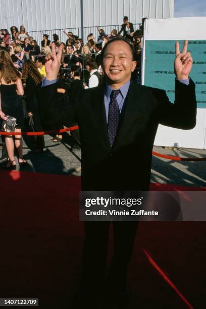 Hong Kong film director John Woo gives the peace sign as he attends the Hollywood premiere of 'Mission: Impossible 2,' held at Mann's Chinese Theatre...