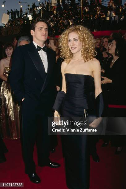 American actor Matt Dillon, wearing a tuxedo and bow tie, and American actress Sarah Jessica Parker, wearing a black strapless evening gown with a...