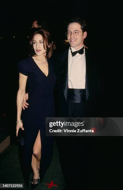 American actress Sarah Jessica Parker, wearing a midnight blue dress, and her husband, American actor Matthew Broderick, wearing a tuxedo, bow tie...