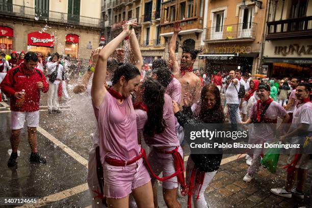 Revellers have water poured onto them during the opening day or 'Chupinazo' of the San Fermin Running of the Bulls fiesta on July 06, 2022 in...