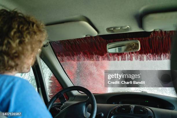 man washing his car in a drive-by car wash - car wash stock pictures, royalty-free photos & images