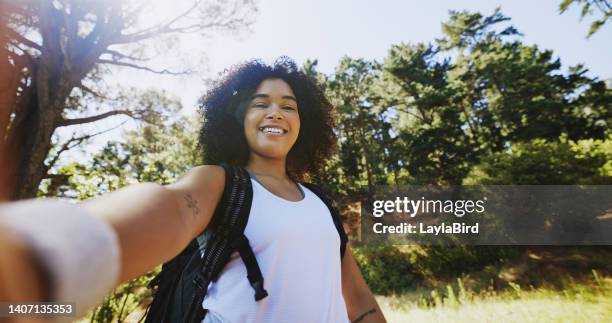 ritratto di un escursionista che scatta selfie ed esplora un sentiero nella natura in una giornata di sole con spazio per le copie. donna nera sorridente con capelli ricci afro che si godono l'aria fresca durante un trekking in solitaria nel deserto - gara sportiva individuale foto e immagini stock