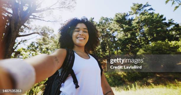 portrait of a hiker taking selfies and exploring a trail in nature on a sunny day with copy space. smiling black woman with curly afro hair enjoying the fresh air during a solo trek in the wilderness - individual event stock pictures, royalty-free photos & images